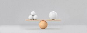 A tan ball acts as a fulcrum balancing a board that has three balls on one side and one larger ball on the other side, representing balance and simplicity.