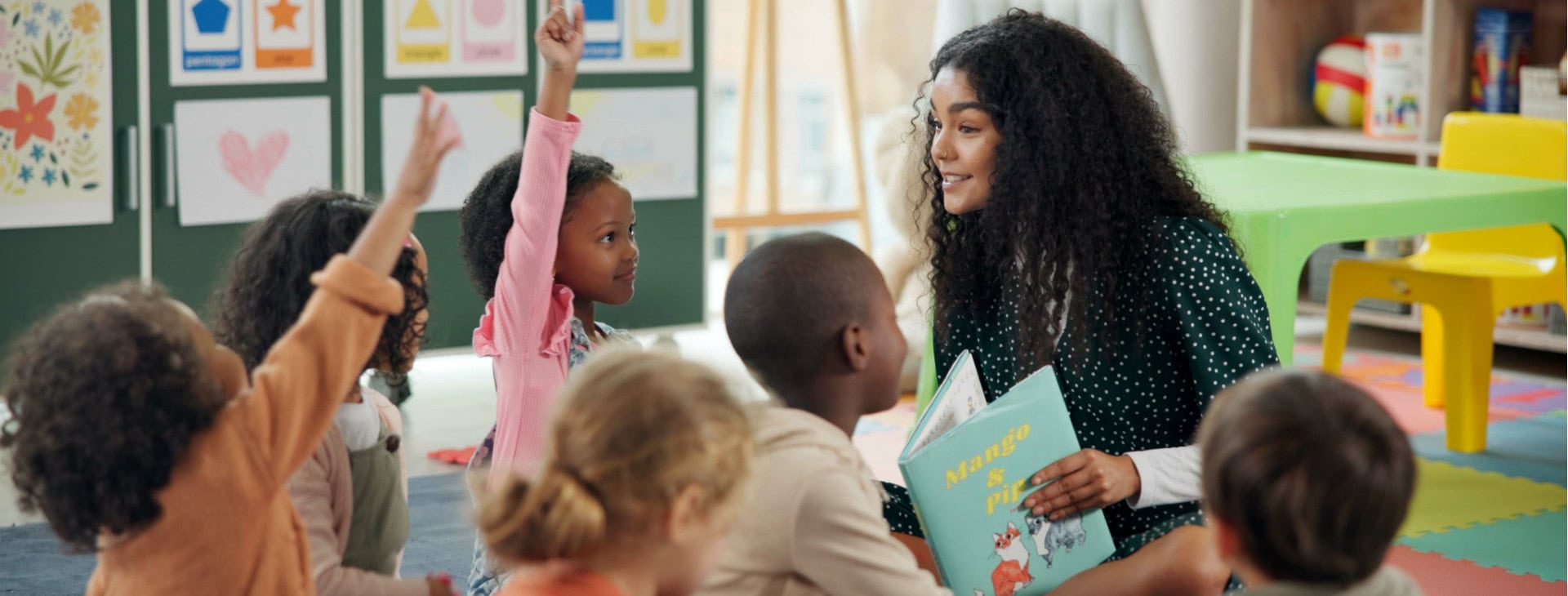 A teacher reading to a classroom of children.