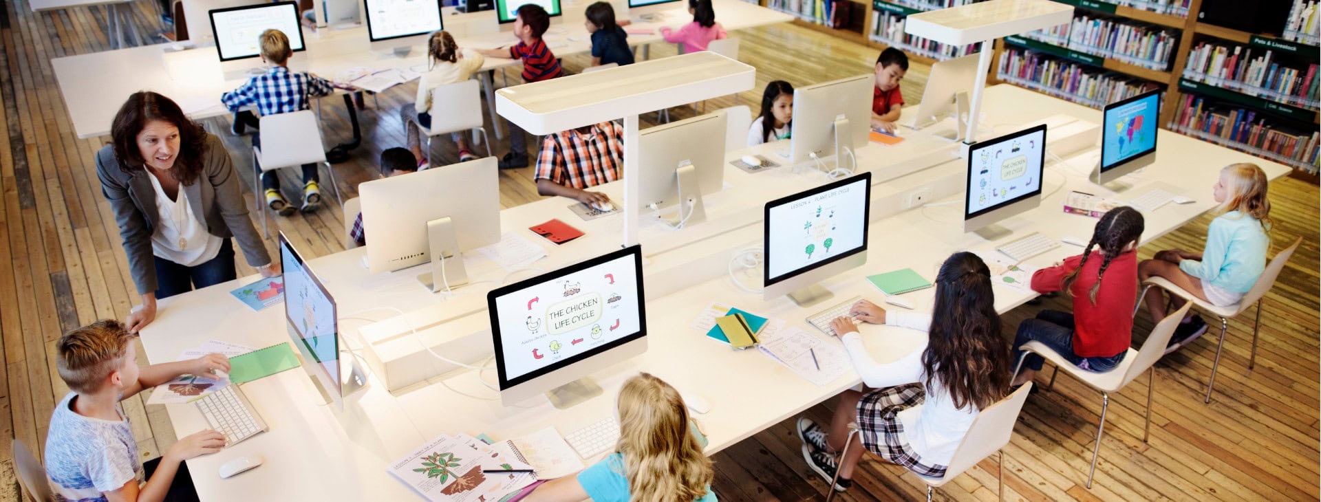 a room of students taking tests on computers.