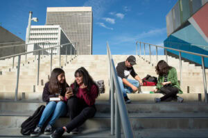 young people sitting on steps outdoors, talking