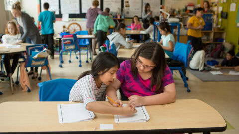 Fourth graders work together in a classroom.